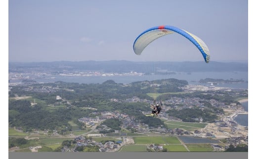 海の上を飛ぶパラグライダー遊覧飛行