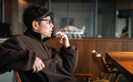 椅子に座っている前澤の画像